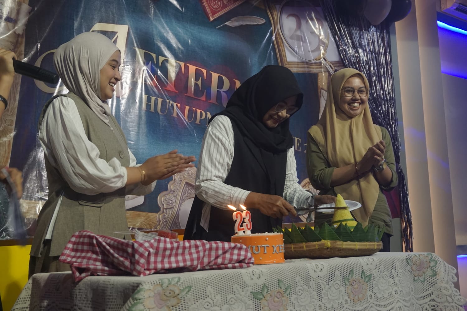 Kepala Laboratorium UPN Televisi, Dra. Dyva Claretta, M.Si., memimpin prosesi pemotongan tumpeng sebagai bagian dari rangkaian perayaan Hari Ulang Tahun ke-23 UPN Televisi dalam acara Aeterna 2026. (Dok. Pribadi)